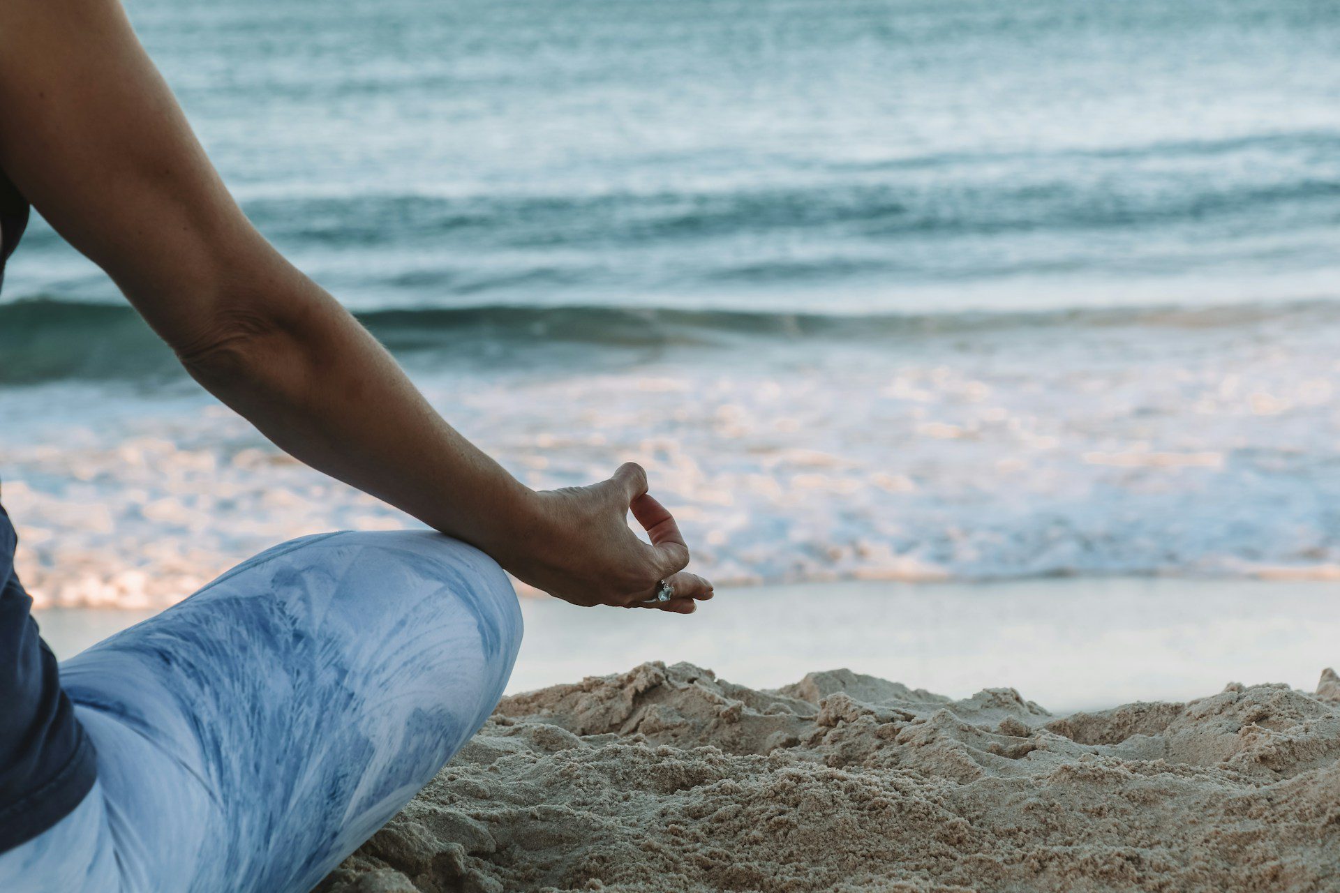 Womens Retreat Featured Image Woman sitting peacefully on the beach at sunrise